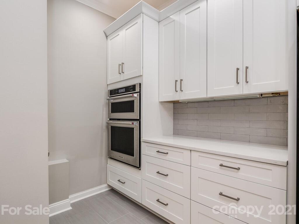 3115 Planters Ridge Road Charlotte, NC 28270 - Photo 33 of 44 a kitchen with white cabinets and appliances