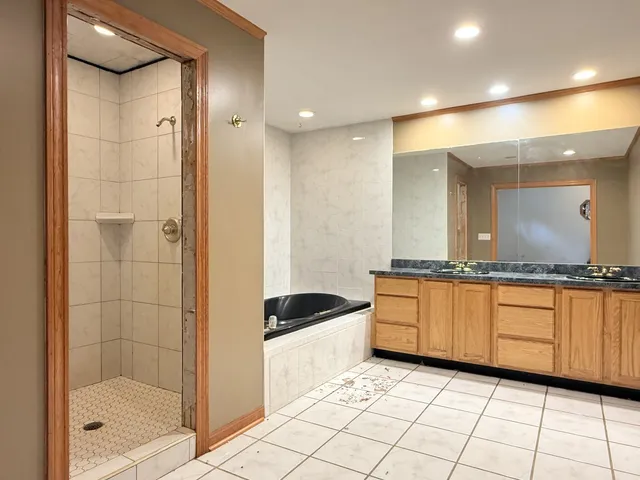 a bathroom with a granite countertop sink mirror and bathtub