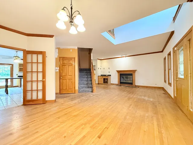 a view of empty room with a fireplace and chandelier