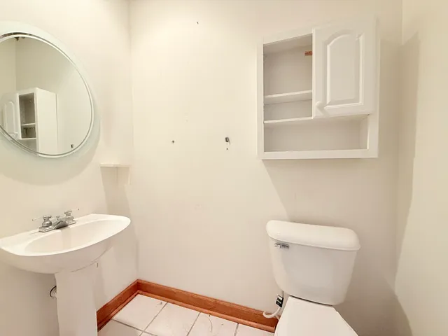 a bathroom with a toilet a sink and mirror