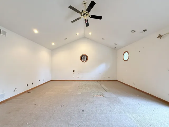 an empty room with a window and a ceiling fan
