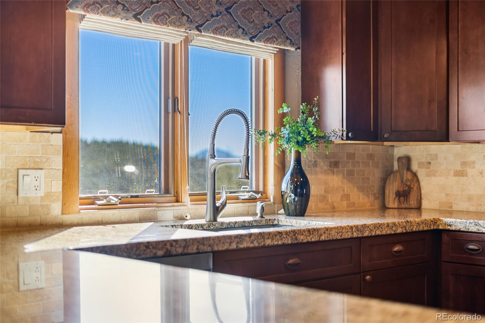 685 Jesse Lane Bailey, CO 80421 - Photo 12 of 50 a kitchen with granite countertop a sink and wooden cabinets