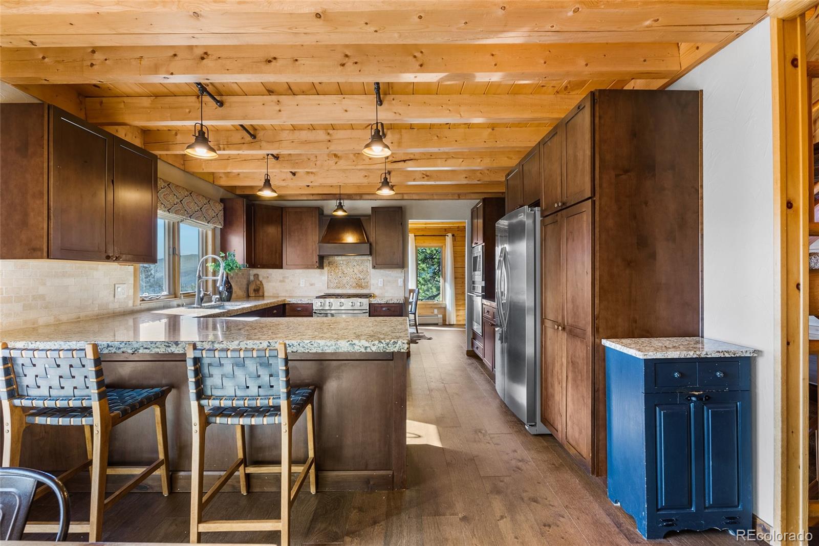 685 Jesse Lane Bailey, CO 80421 - Photo 13 of 50 a kitchen with a sink a refrigerator and wooden cabinets