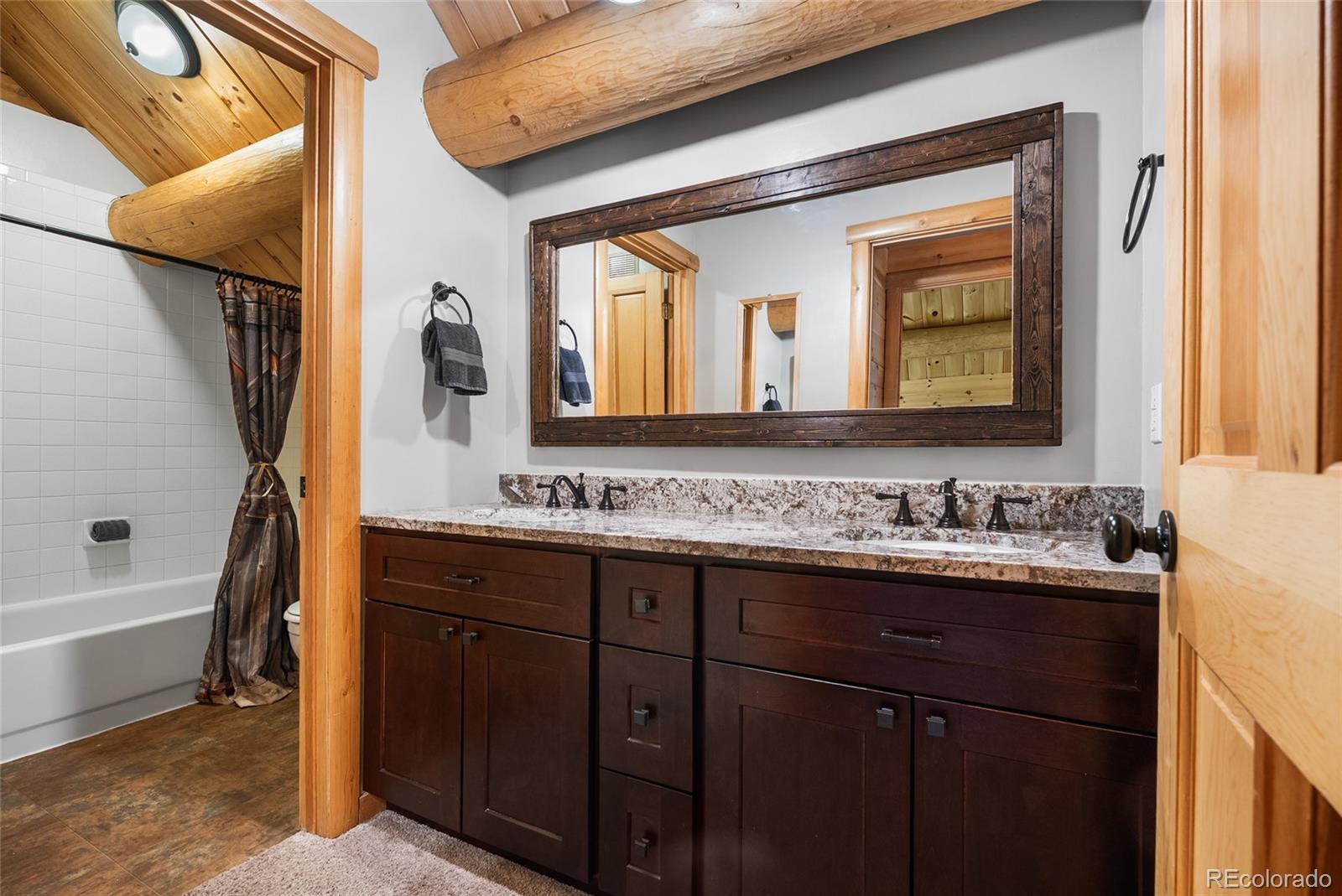 685 Jesse Lane Bailey, CO 80421 - Photo 29 of 50 a bathroom with a double vanity sink and mirror with bathtub