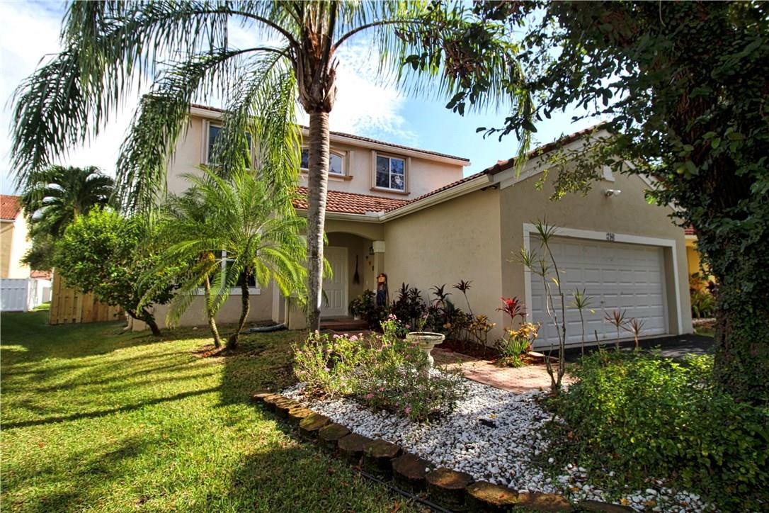 790 Chimney Rock Road Weston, FL 33327 - Photo 1 of 18 a backyard of a house with potted plants and palm trees