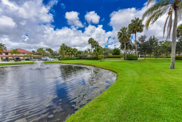 a view of a fountain in front of a house with a yard