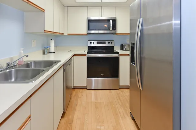a kitchen with kitchen island a counter top space a sink and stainless steel appliances