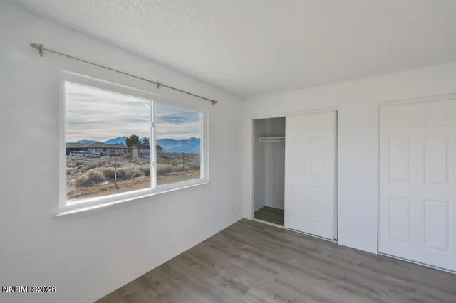 a view of a big room with wooden floor and a ceiling fan