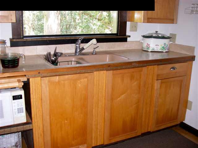 22 West Kuiaha Road Haiku, HI 96708 - Photo 4 of 23 a kitchen with a window a sink and wooden cabinets