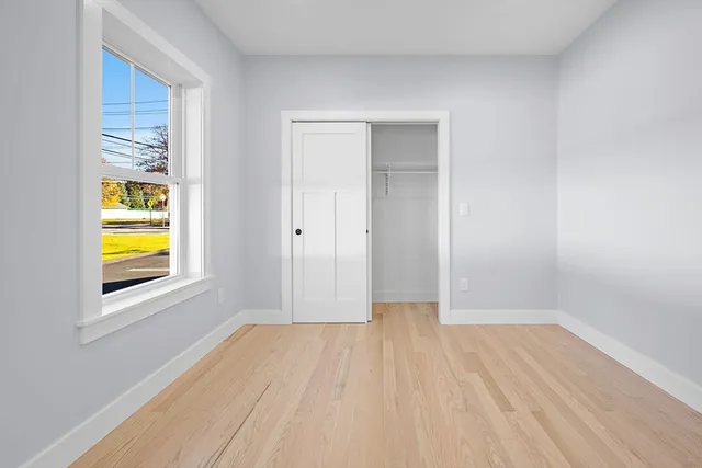 a view of a room with wooden floor and a window