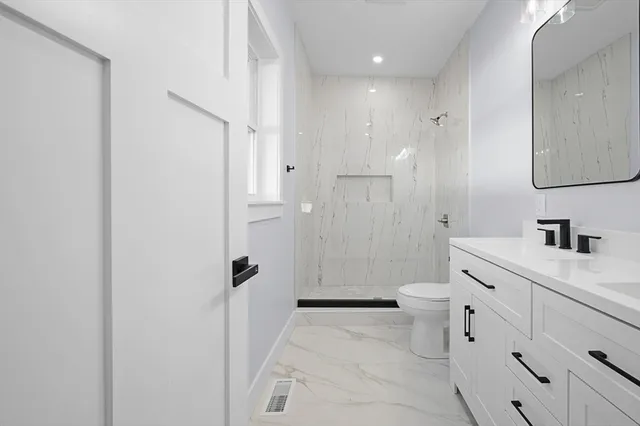 a bathroom with a granite countertop sink toilet and shower