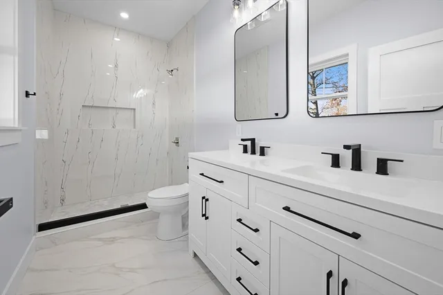 a bathroom with a toilet sink and mirror
