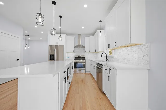 a large kitchen with stainless steel appliances lots of counter space and wooden floor