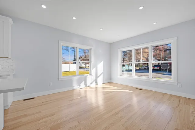 a view of empty room with a window and wooden floor