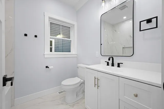 a bathroom with a toilet sink and mirror