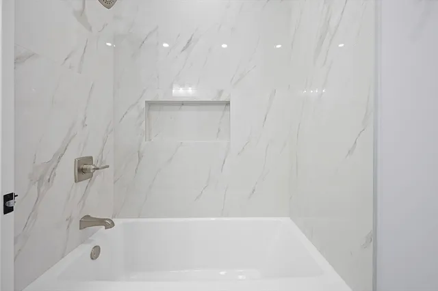 a bathroom with a bathtub and shower