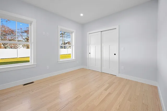 a view of an empty room with window and closet