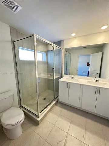 a bathroom with a shower sink mirror and toilet