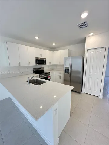 a kitchen with stainless steel appliances a refrigerator sink and microwave