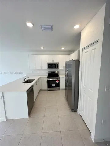 a kitchen with a refrigerator and a sink