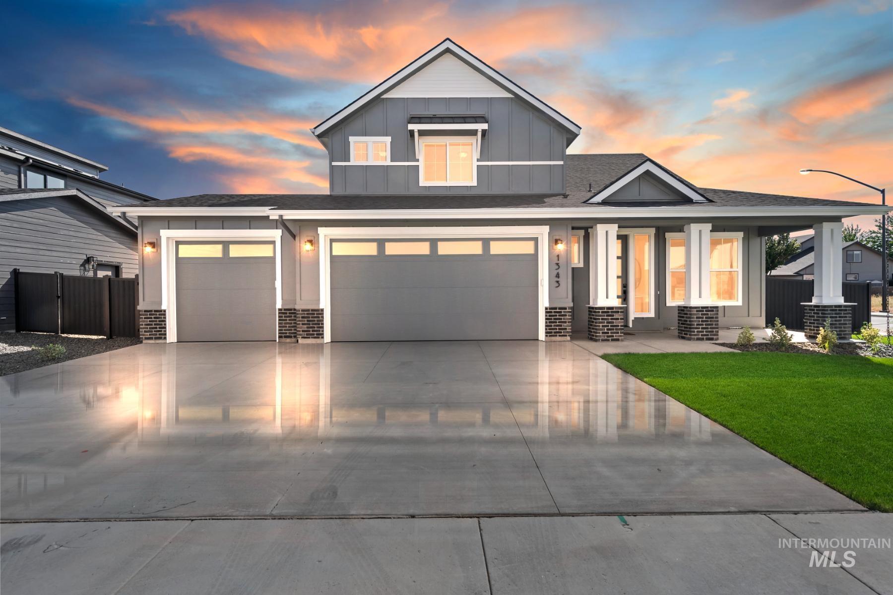 View of front facade featuring board and batten siding, brick siding, concrete driveway, roof with shingles, and covered porch