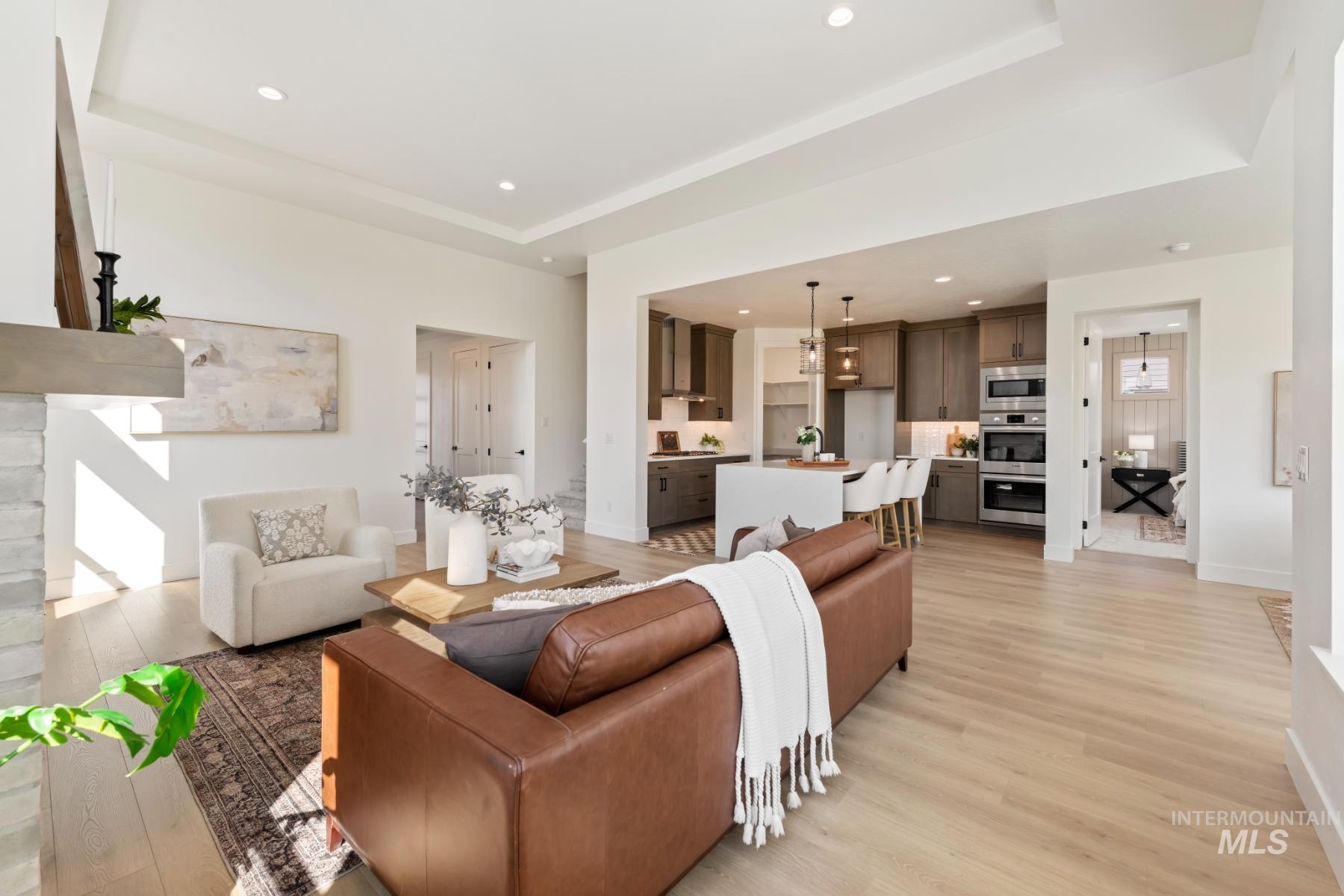 945 West Malbar Street Meridian, ID 83646 - Photo 13 of 42 Living room featuring recessed lighting, light wood-style floors, and a tray ceiling