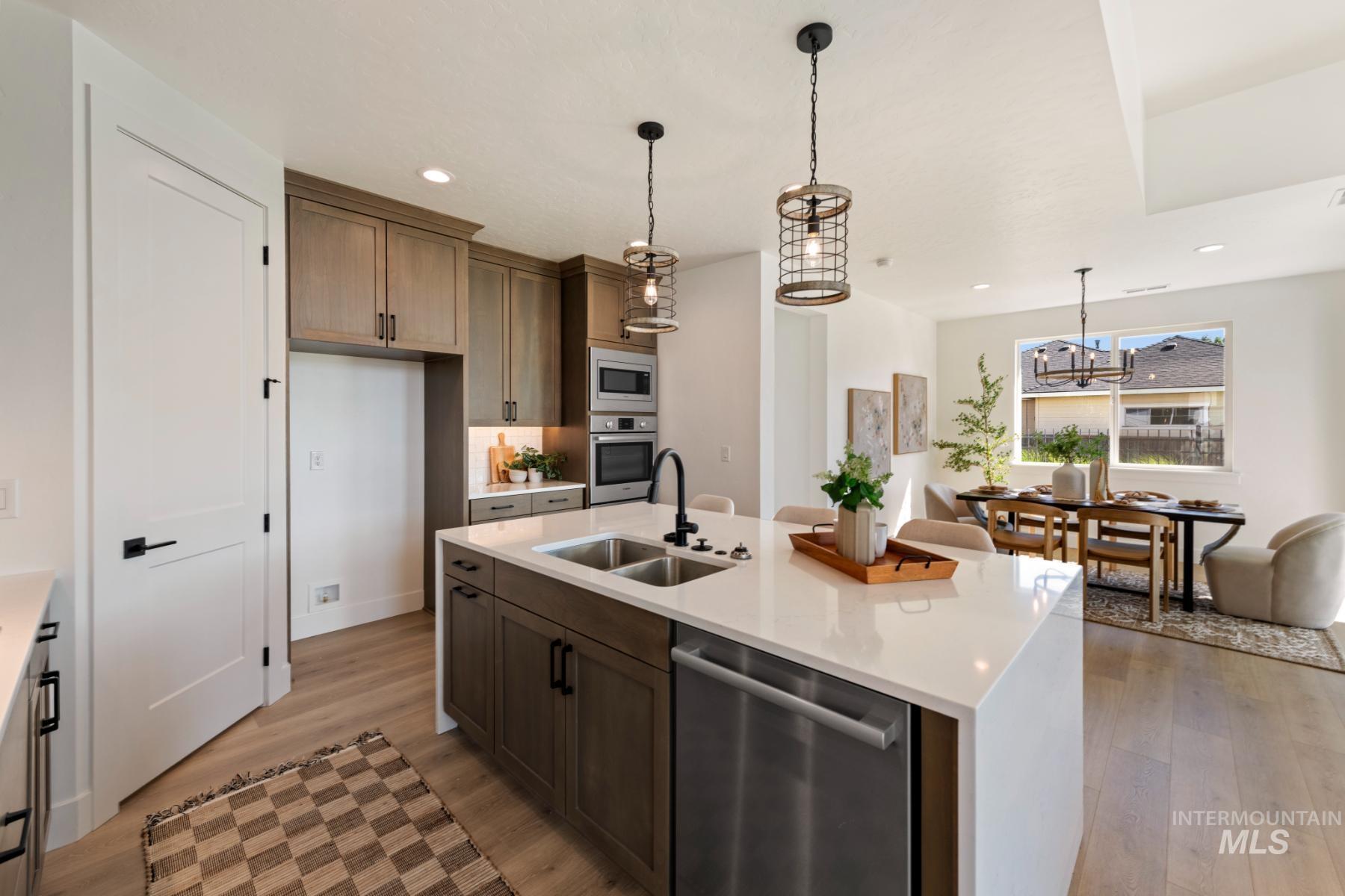 945 West Malbar Street Meridian, ID 83646 - Photo 18 of 42 Kitchen featuring hanging light fixtures, stainless steel appliances, light wood finished floors, light stone counters, and recessed lighting
