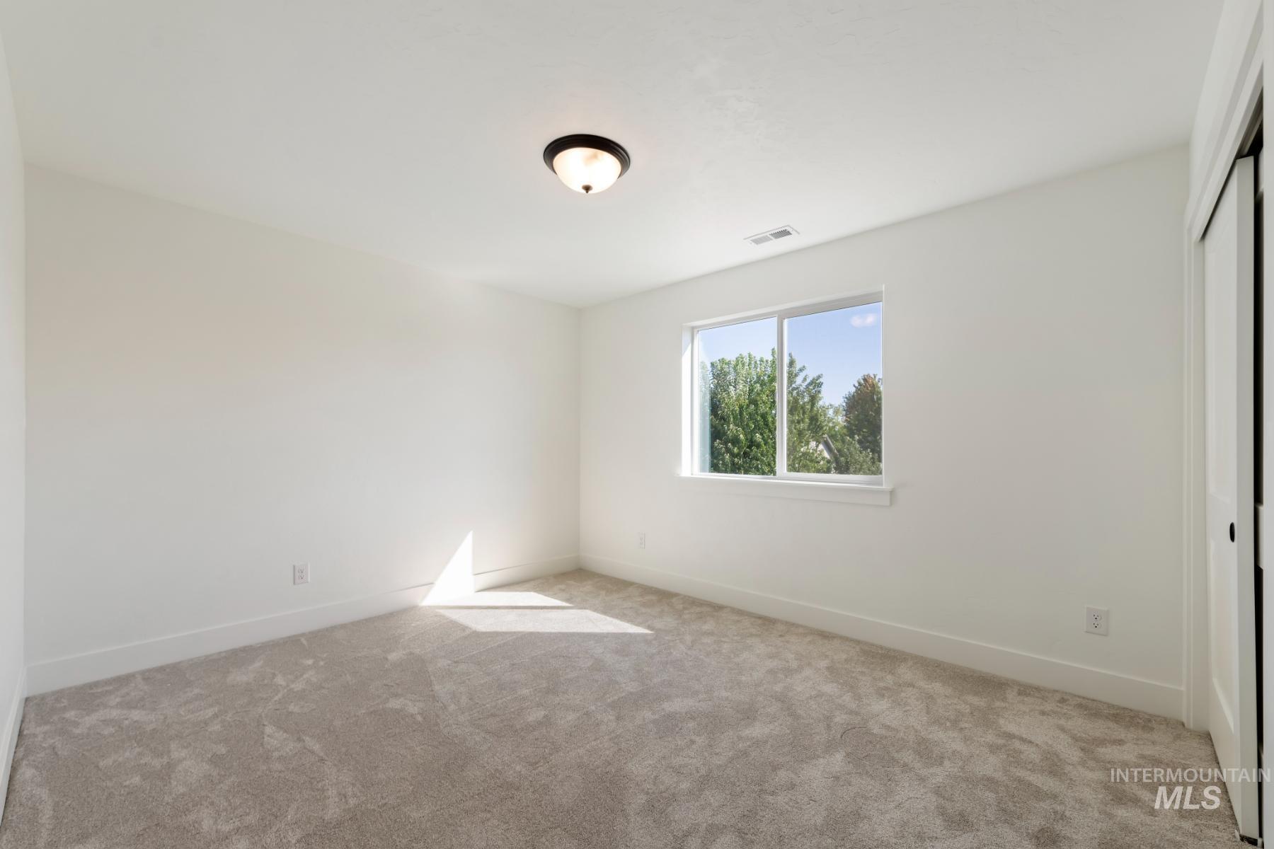 945 West Malbar Street Meridian, ID 83646 - Photo 25 of 42 Unfurnished bedroom with light colored carpet and a closet