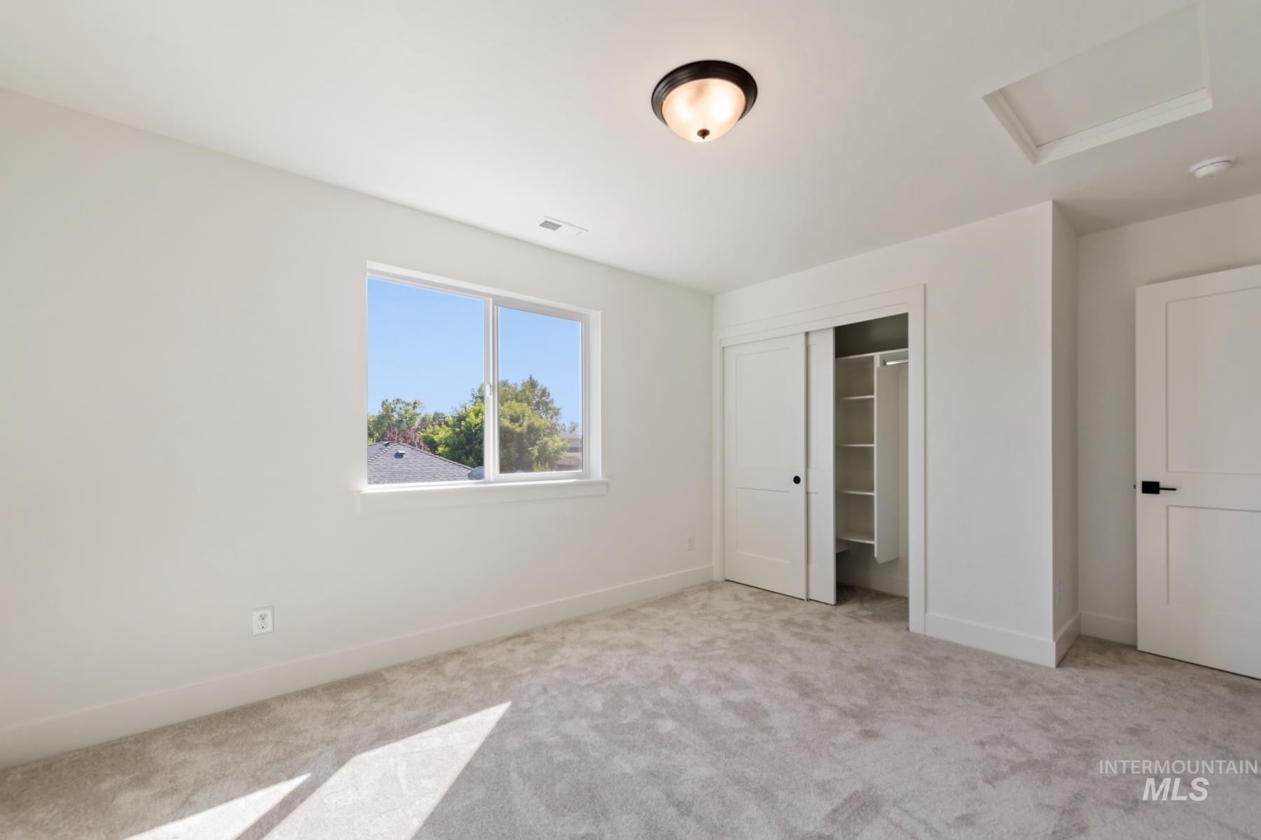 945 West Malbar Street Meridian, ID 83646 - Photo 26 of 42 Unfurnished bedroom featuring attic access, carpet flooring, and a closet