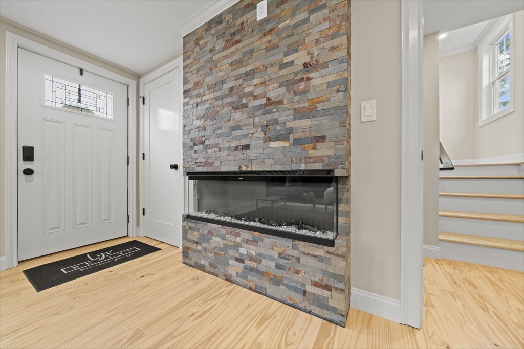 162 High Street, Unit B Danvers, MA 01923 - Photo 13 of 32 a living room with a fireplace and a wooden floor