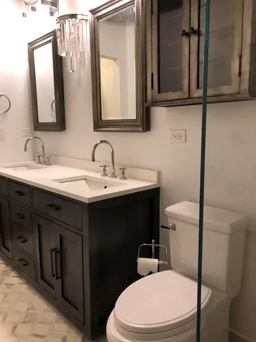 a bathroom with a toilet sink and mirror
