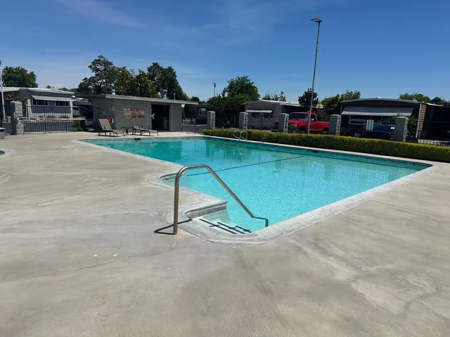 a view of swimming pool with outdoor seating and a garden