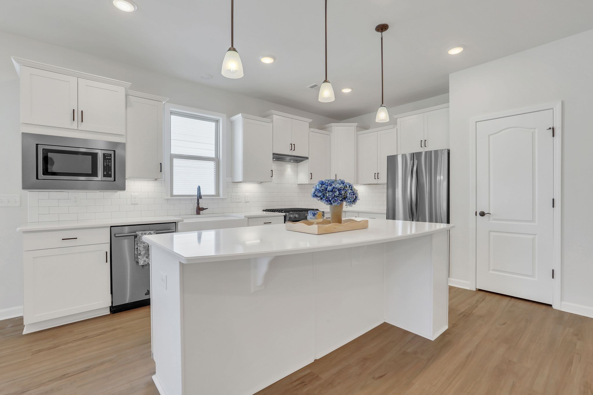 1084 Sumner Grove Spring Hill, TN 37174 - Photo 13 of 40 a kitchen with kitchen island a sink stainless steel appliances and white cabinets