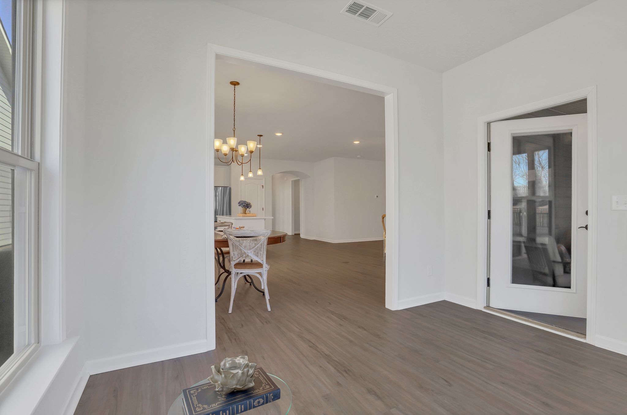1084 Sumner Grove Spring Hill, TN 37174 - Photo 28 of 40 a dining room with wooden floor a chandelier a wooden table and chairs