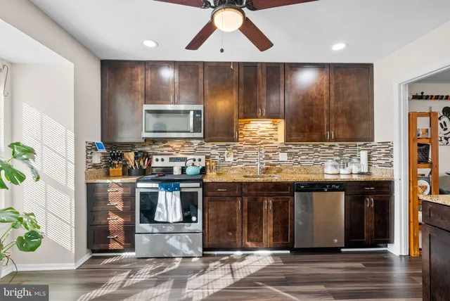 a kitchen with stainless steel appliances granite countertop a stove a sink and a microwave