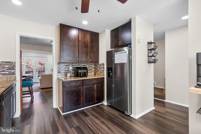 a kitchen with stainless steel appliances a refrigerator and wooden floor