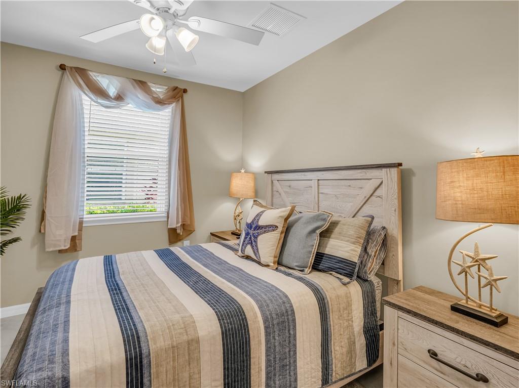14695 Edgewater Circle Naples, FL 34114 - Photo 18 of 39 a bedroom with a bed and dresser with mirror