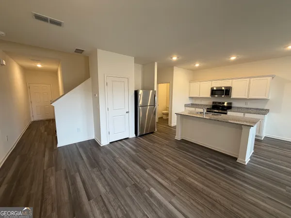 a large kitchen with stainless steel appliances granite countertop a stove a sink and a refrigerator