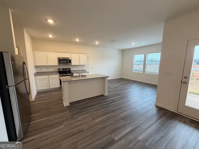 a kitchen with stainless steel appliances a refrigerator sink and microwave