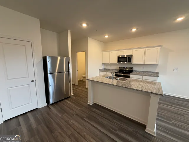 a kitchen with stainless steel appliances granite countertop a refrigerator microwave and stove