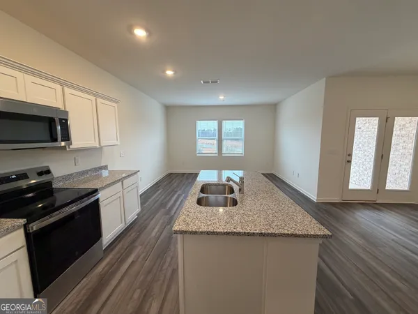 a kitchen with granite countertop stainless steel appliances a stove sink and microwave