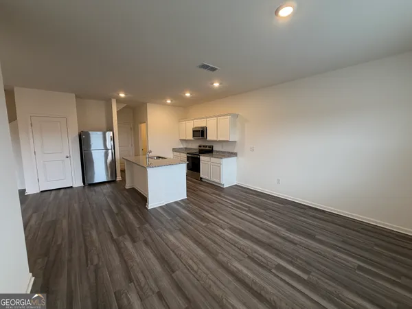a view of a kitchen with a sink and a refrigerator