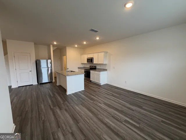 a view of a kitchen with a sink and a refrigerator