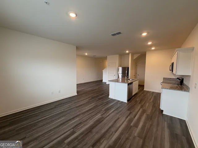 a view of kitchen with wooden floor and electronic appliances