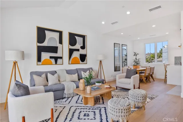 a living room with furniture kitchen view and a window