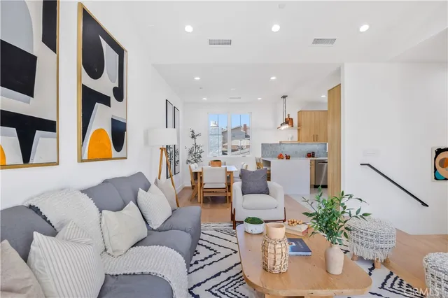 a living room with furniture kitchen and a potted plant