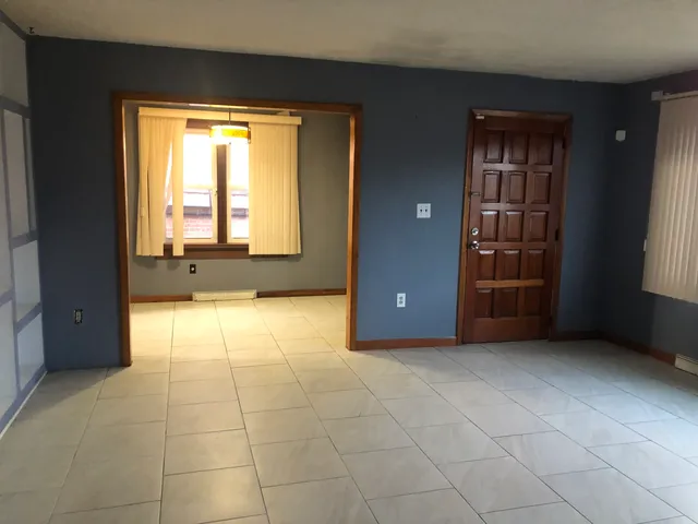 a view of an empty room with a fireplace and a window