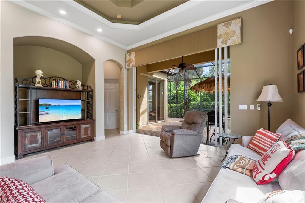 5757 Mango Circle Naples, FL 34110 - Photo 14 of 38 a living room with furniture a flat screen tv and floor to ceiling window
