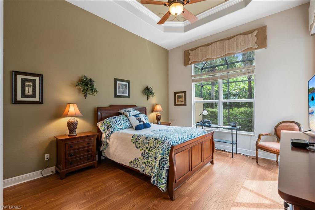 5757 Mango Circle Naples, FL 34110 - Photo 16 of 38 a bedroom with a bed a chandelier and a window