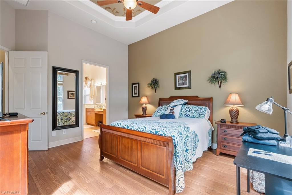 5757 Mango Circle Naples, FL 34110 - Photo 18 of 38 a bedroom with a bed and a chandelier